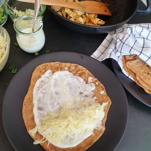 gebackener Urkorn Tortilla mit Topping auf schwarzem Teller