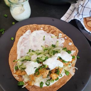 Urkorn Tortilla oder Fladenbrot mit Gemüse und Fleisch auf schwarzer Fläche