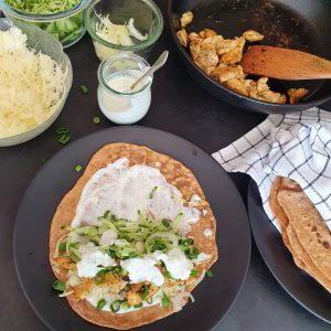 Urkorn Tortilla mit Füllung. Zutaten für die Füllung im Hintergrund