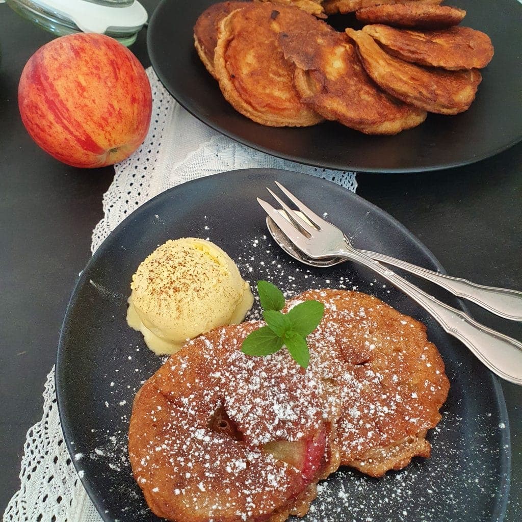 Apfelküchle mit Vanilleeis mit Gabel und Löffel