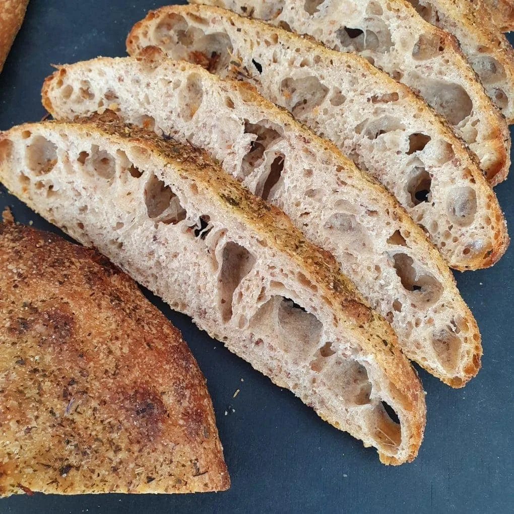 Wildbakers Focaccia aufgeschnitten auf schwarzem Tisch