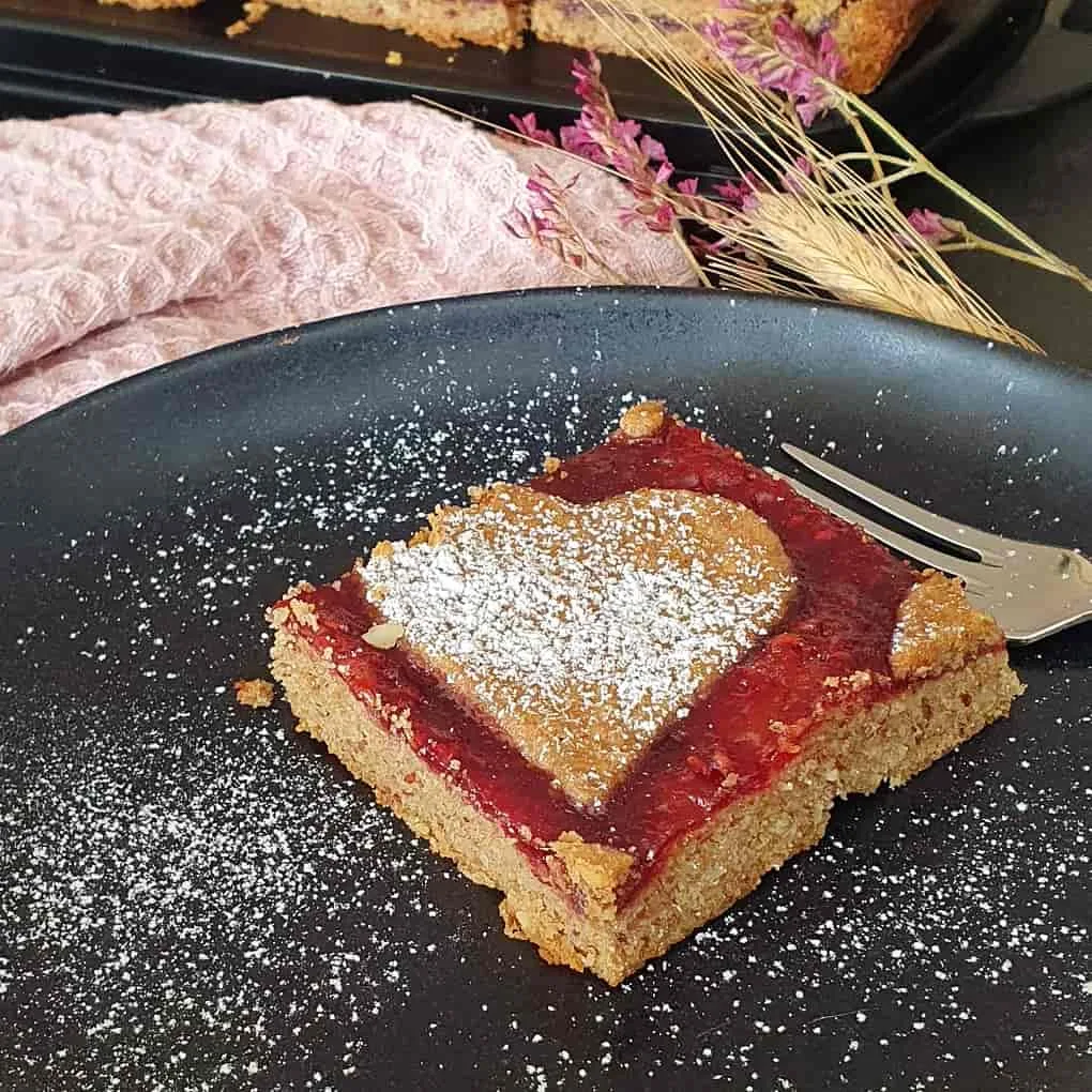 Linzerschnitte servierfertig auf einem schwarzen Teller