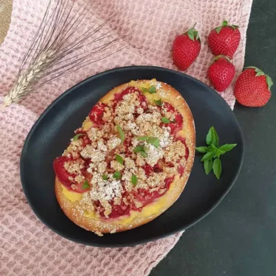 süße Erdbeer-Pizza angerichtet auf schwarzem Teller