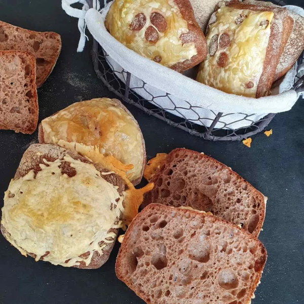 Herbstwald Käsebrötchen neben einem Brotkorb auf schwarzem Tisch