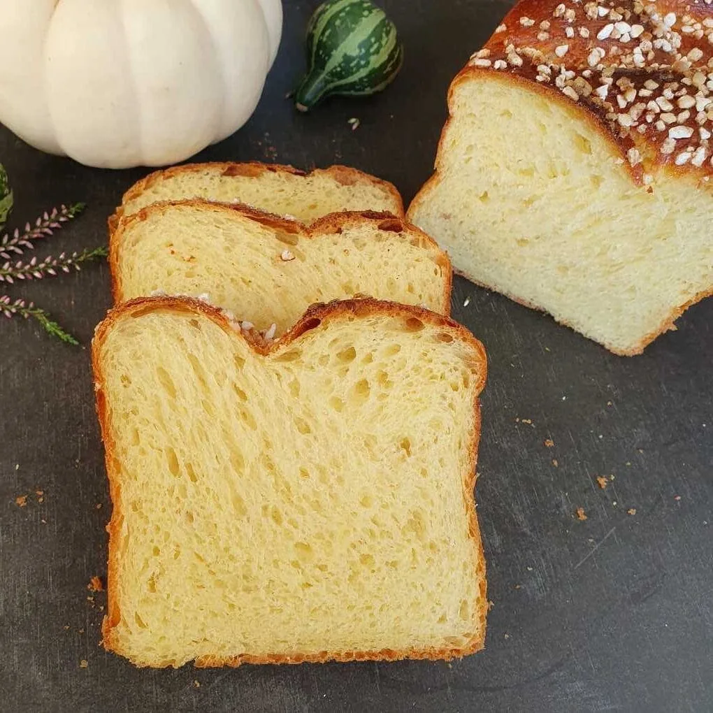 3 Scheiben Hefestuten 550 aus Gelbmehlweizen Typ 550 aufgeschnitten und auf schwarzem Brett serviert