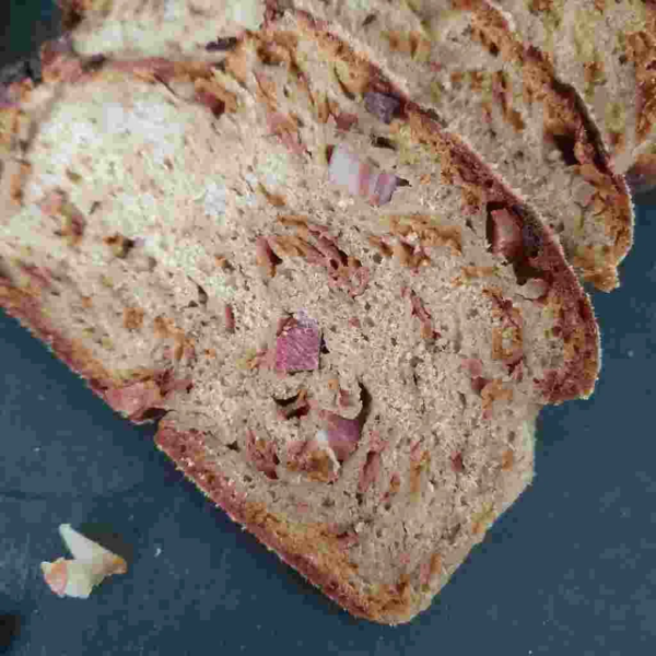 Nahaufnahme von einer Brotscheibe Urkorn Männerbrot mit Speck und Zwiebel