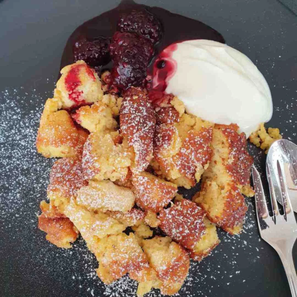 süßer Polenta-Schmarrn mit Quark und Brombeersoße angerichtet
