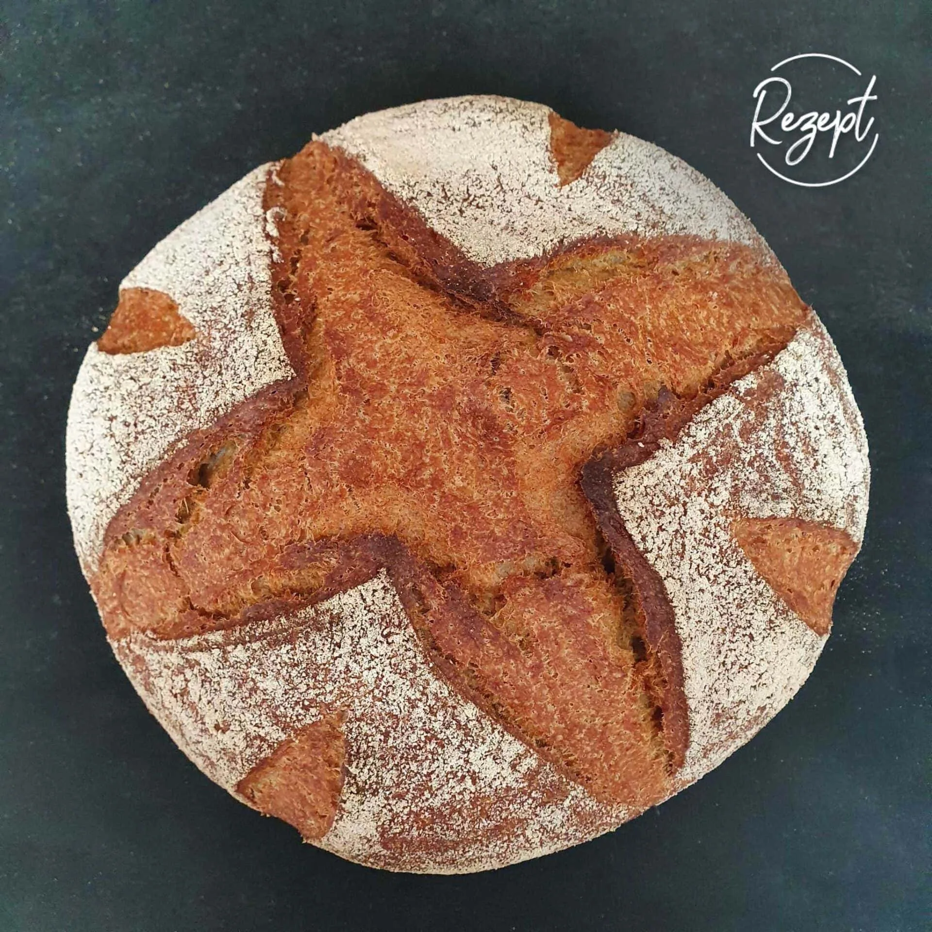 Brotlaib Khorasan mit Quark ohne Hefe von oben auf schwarzem Brett