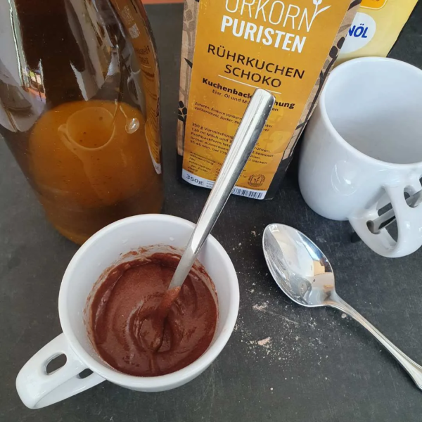 Teig für Tassenkuchen Schoko in der Tasse mit Dekoartikel