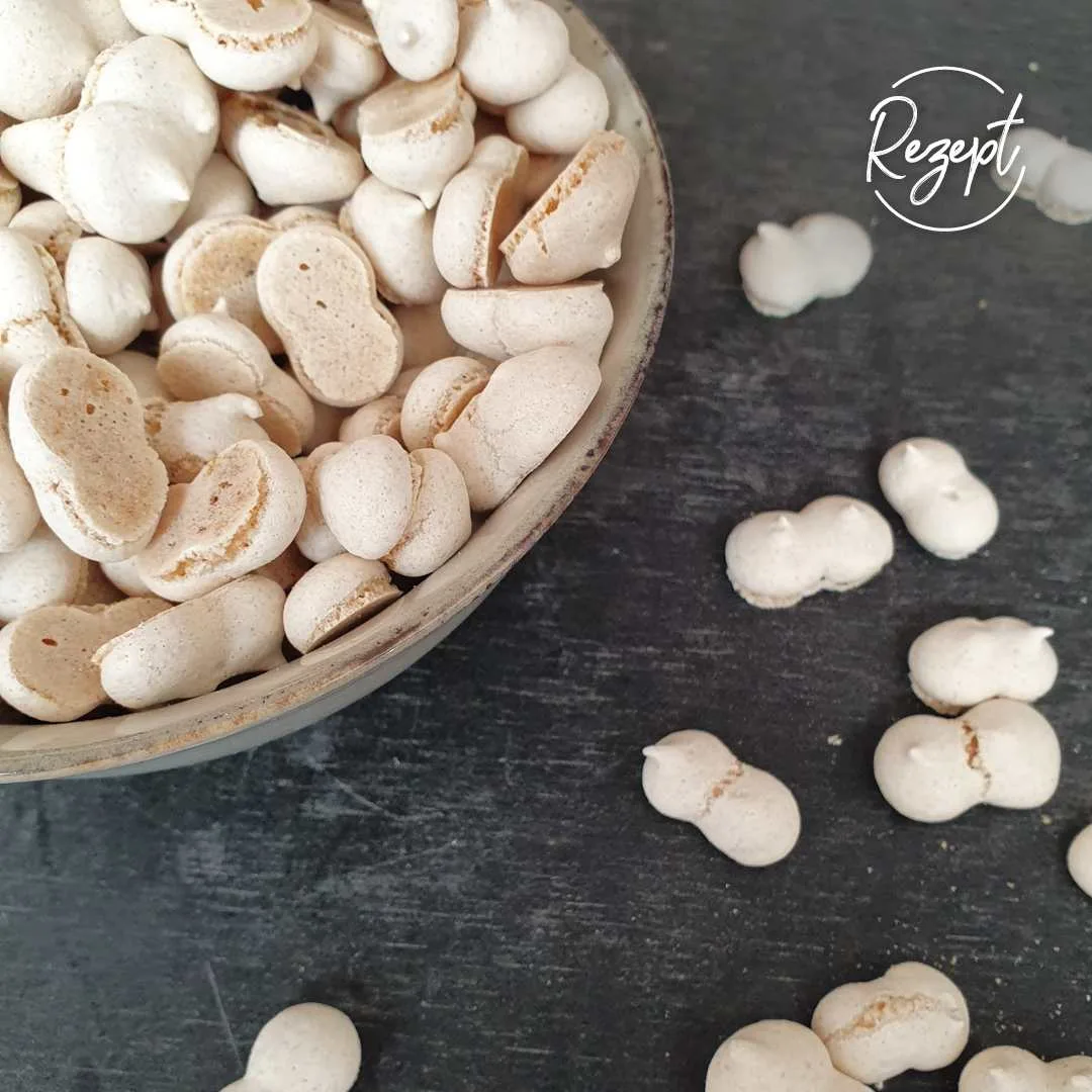 Wibele in Gebäckschale. ein paar Wibele daneben auf schwarzem Tisch