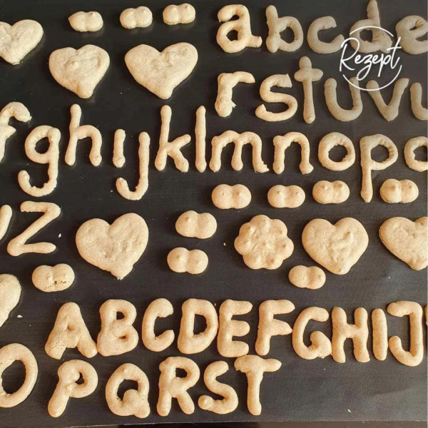 Buchstaben aus Wibele Teig auf schwarzer Backfolie