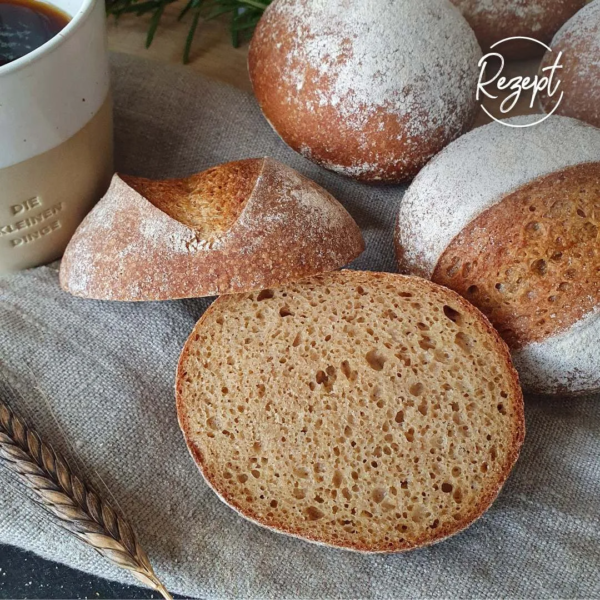 Brötchen aufgeschnitten, graues Tuch, Kaffeetasse, Einkornähre