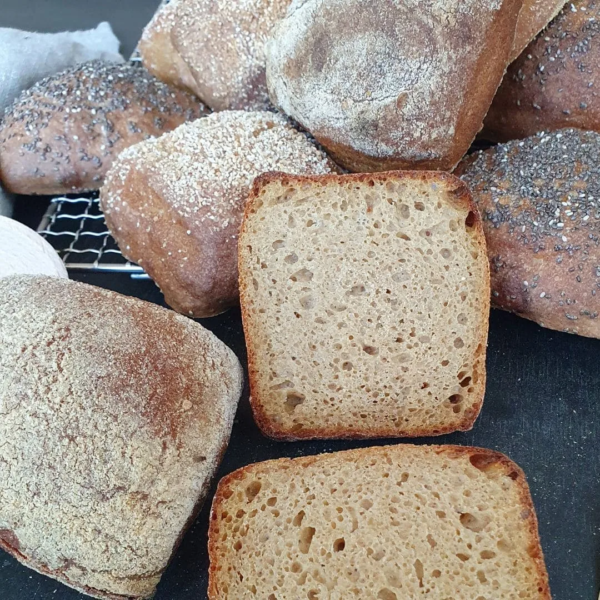 verschiedene Einkornbrötchen Version III. ein brötchen liegt aufgeschnitten mit Schnittfläche nach oben auf dem Tisch