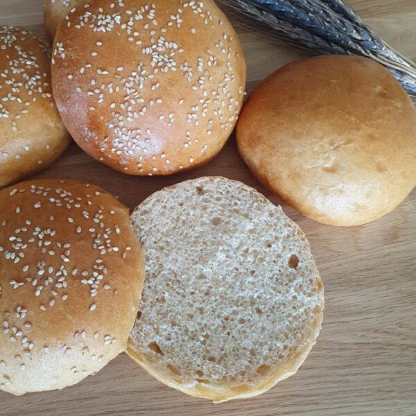 Hamburger Buns. Aufgeschnitten auf Holztisch. Ähre vom Bluevelvet in der Ecke