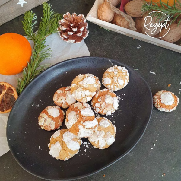Orangen Laibchen auf schwarzem Teller mit Weihnachtsdeko