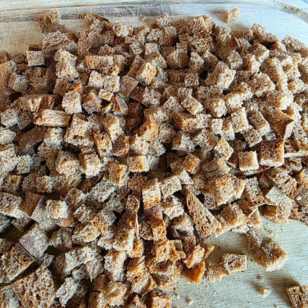 Urkornbrot in würfel geschnitten auf einem holzbrett