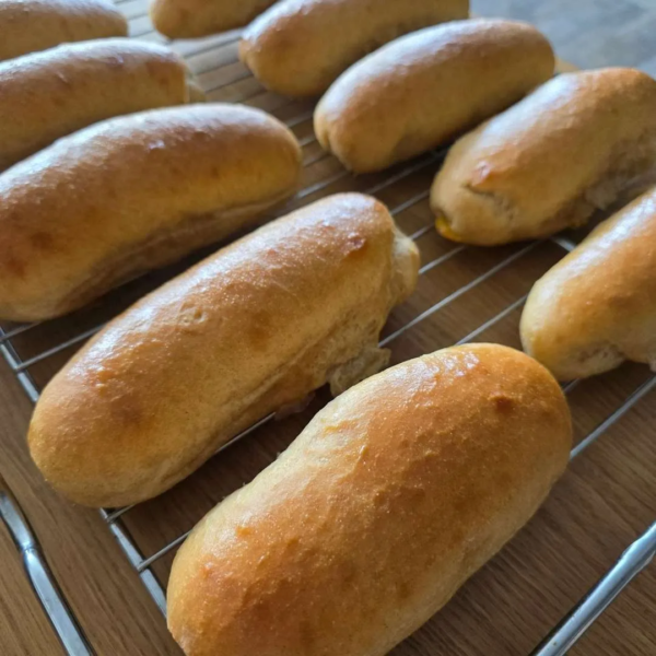 Hotdog Brötchen fertig gebacken nebeneinander auf einem Gitterrost