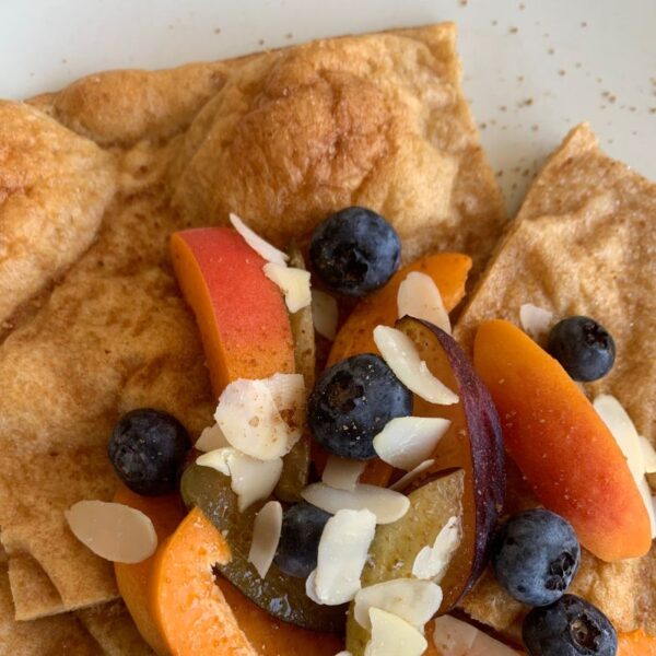 Pfannkuchenstück mit Obst und Mandeplättchen belegt. Nahaufnahme