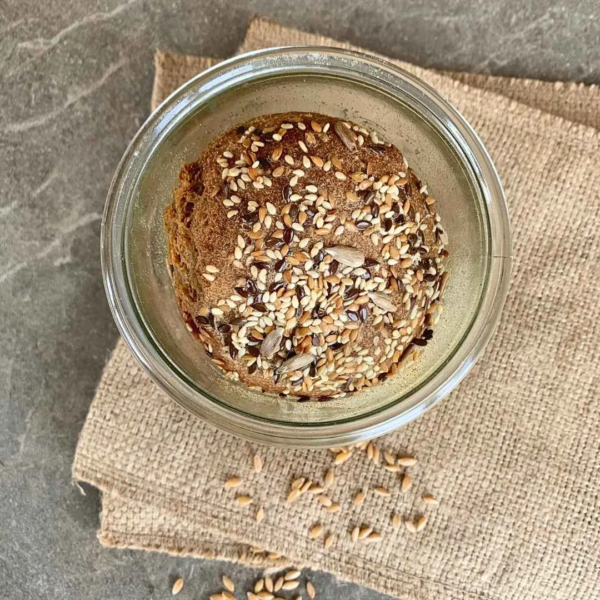 Vogelperspektive eines Vollkornbrot im Weckglas gebacken. Glas steht auf Jute Topflappen auf grauem Tisch